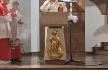 Mężczyzna przy mównicy, Dwoje chłopców obok. 