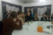Ksiadz z mlodzieza przy stoliku