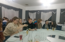 Ksiadz wraz z mlodzieza przy stoliku