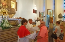 Ksiądz i ministrant udzielający komunii 